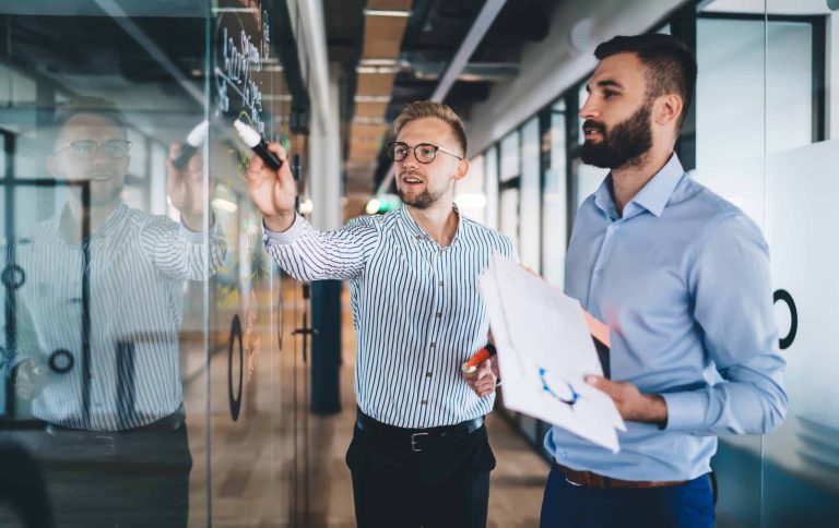 Smiling male employees discussing cooperation planning having pr
